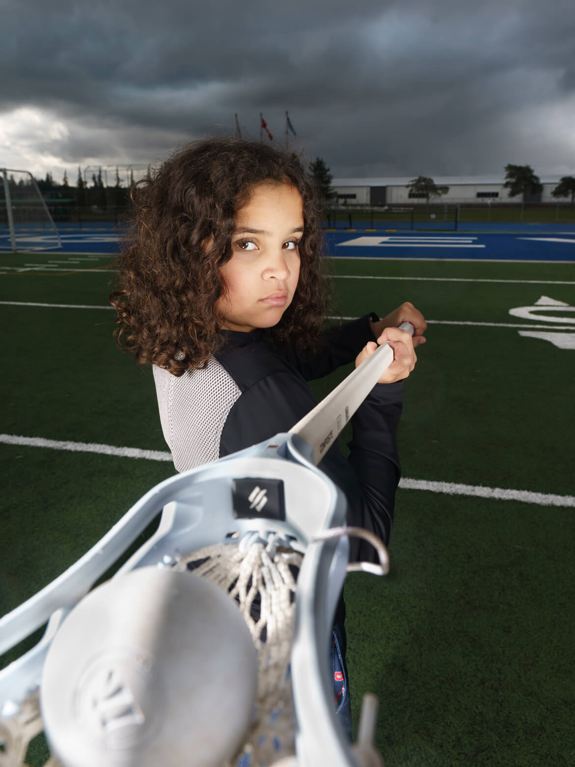 Girl playing lacrosse wearing Warrio Hill's Youth unisex long sleeve shirt